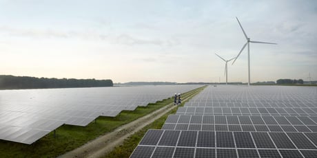 Aurinkopaneeleja ja tuuliturbiineja avoimella kentällä